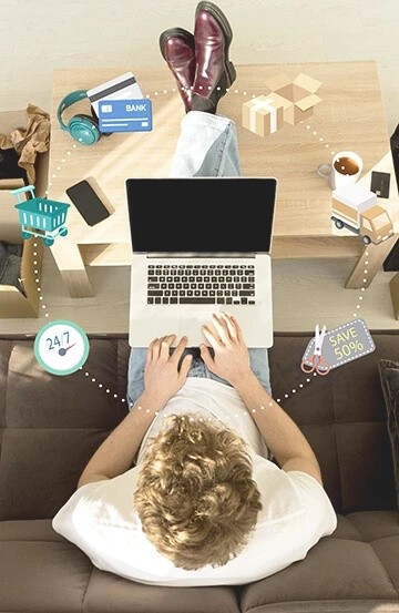 A man sitting in a salon chair, using a computer for his work.